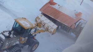 Трактор чистит снег. Конец зимы уборка снега