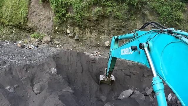 Строительство, экскаватор копает чёрный песок