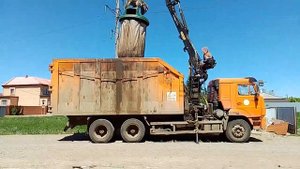 Мусоровоз КАМАЗ грузит бак