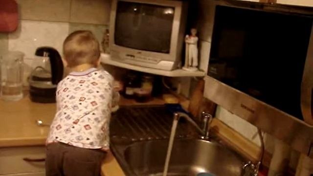 Малыш моет посуду