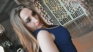 Девушка в синем платье позирует на видео