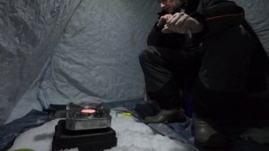Один в палатке на зимней рыбалке.