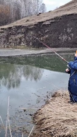 Ребенок ловит рыбу на речке
