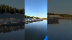 Разгрузка баржи на реке Вытегра. Вид с теплохода.