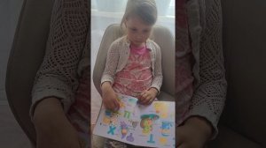 Арина повторяет буквы.
