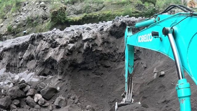 Строительство, экскаватор копает чёрный песок