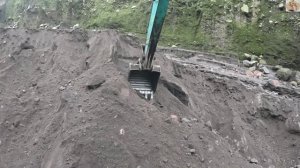 Строительство, экскаватор копает чёрный песок