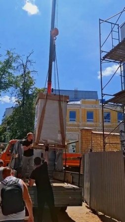 краном грузим кондиционер на крышу