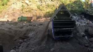 Строительство, экскаватор копает чёрный песок