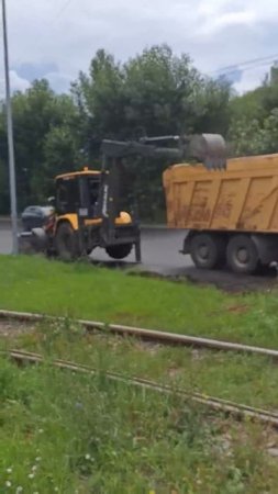 Экскаватор загружает землю в самосвал