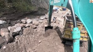 Строительство, экскаватор копает чёрный песок