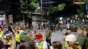 Протестующие в Белграде начали бросать бутылки и мусор в полицейский кордон.