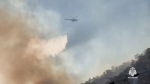В Алуште большой пожар на скале: тушат вертолётами!