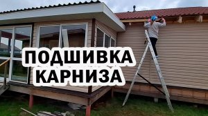 Начинаю подшивать карнизы дома. Саша обшивает веранду