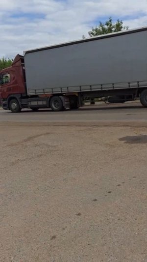 Грузовик фура с прицепом едет по дороге и везет груз
