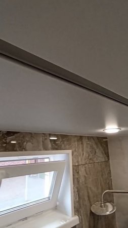 Натяжной потолок в ванной со встроенным карнизом под шторку