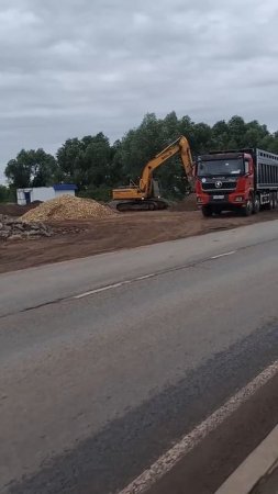 Экскаватор загружает песок в самосвал