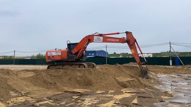 Экскаватор Hitachi ZX180LC 5G, снимает слой песка, осуществляя разработку грунта.