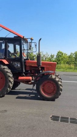 Красный трактор едет по дороге