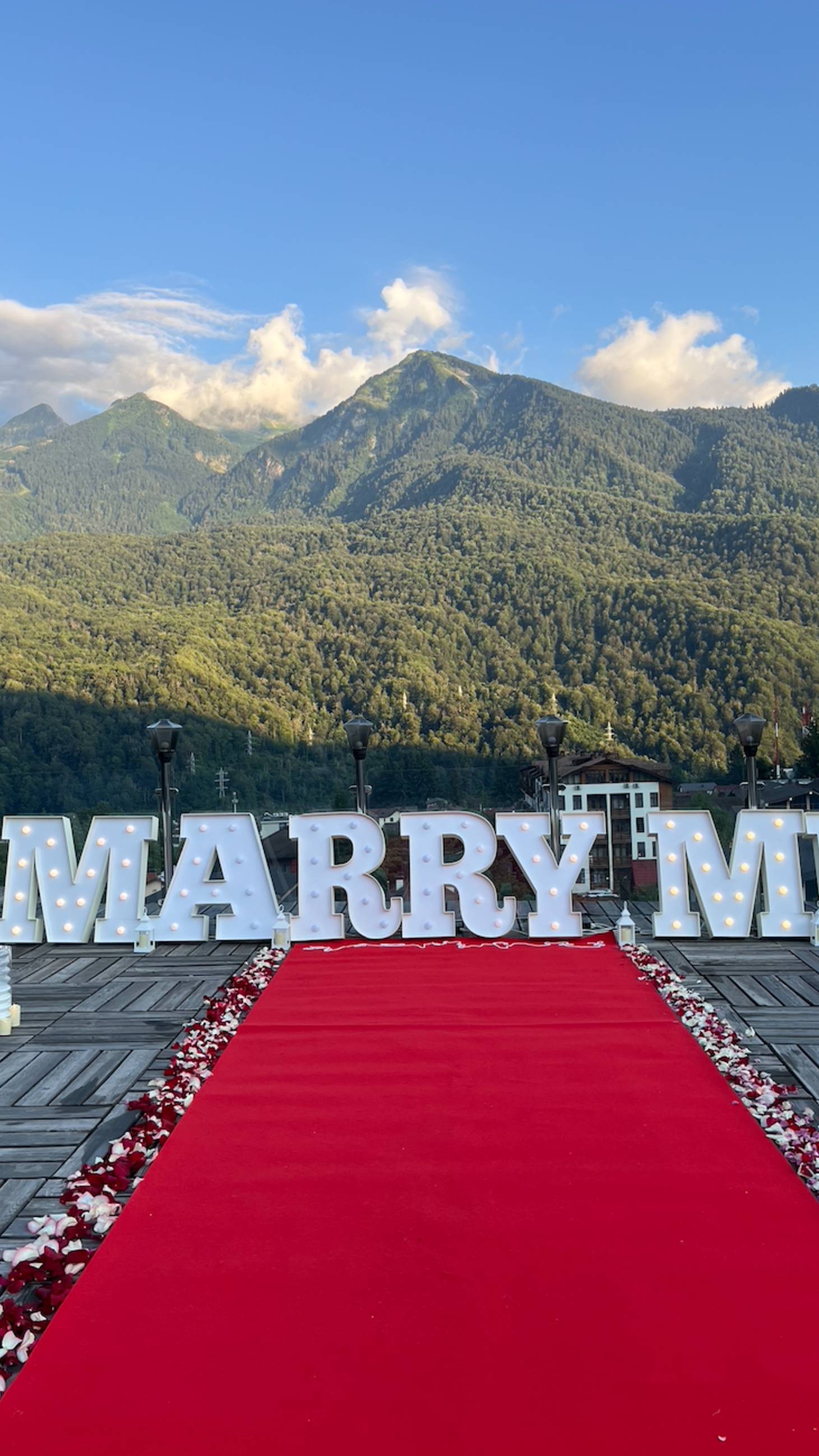 Предложение руки в красной поляне
Буквы MARRY ME с видом на горы