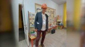 В строительной каске рабочего.