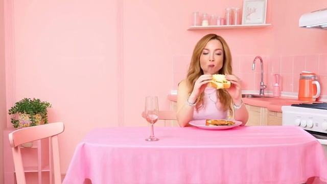 Девушка ест бутерброд в розовой кухне Qwen Chat