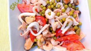 Салат с морепродуктами, красным сочным помидором и нежным молочным зелёным горошком.