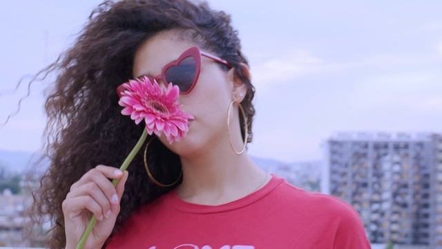 Модель в солнцезащитных очках и с цветком