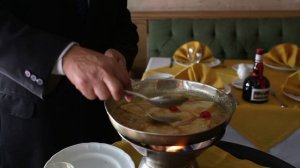 Шеф-повар в черном костюме готовит на огне