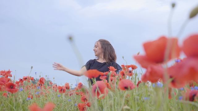 Девочка радостно танцует в поле цветов.
