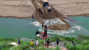 Бульдозер SHANTUI DH перемещает песок в воду