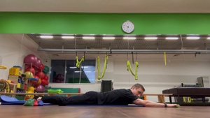 Гиперэкстензия на полу с движением лопаток и разгибанием бедра (в руках палка)