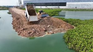 бульдозер SHNTUI Push Stone и 25-тонный самосвал, сбрасывающий камень в озеро