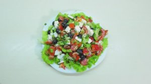 Салат из помидора, сладкого перца,листья салата, сыра фета, оливок и зелени в оливковом масле.