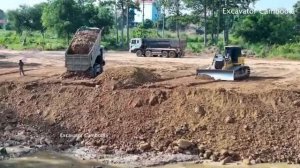 Тяжелый Бульдозер Выталкивает Грунт, А Самосвал Выгружает Его Обратно В Пруд.