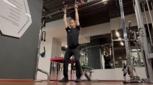 Приседания с противовесом: эспандер, закреплённый сверху