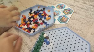 Ника делает улитку из мозаики