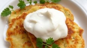 Драники из картошки на тарелке со сметаной