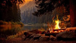 Уютный костер на берегу озера в горах. Успокаивающая атмосфера осенней природы для тихих вечеров.