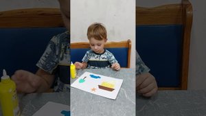 Ромочка делает аппликацию из цветной бумаги, клея и картона