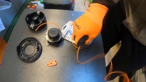 Заправляем леску в катушку триммера.