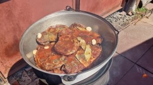 Говяжьи голяшки в казане на костре, томленные до мягкости.