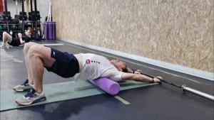 Разгибания грудного отдела через роллер с грифом