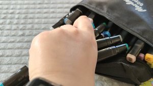 рассматриваю и складываю маркеры для скетчинга в пенал