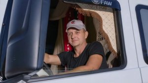 The_camera_slowly_zooms_in_on_the_man's_face,_who_is_sitting_in