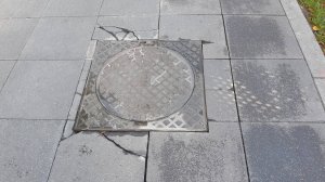 Обрамление люка при подходе мощением из плит.