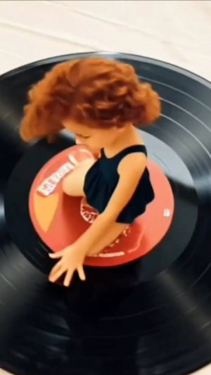 кукла стоит на пластинке