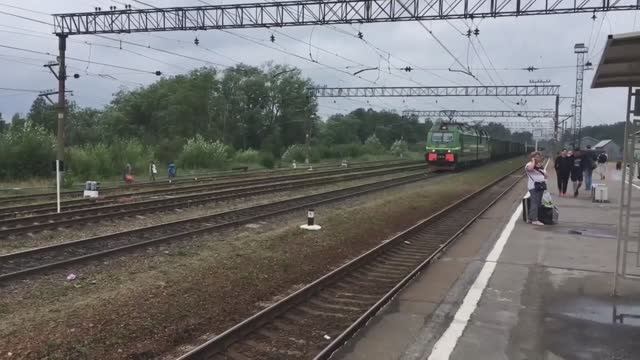 Электровоз 2ЭС4К "Ермак" с грузовым поездом проезжает мимо станции смотреть онлайн