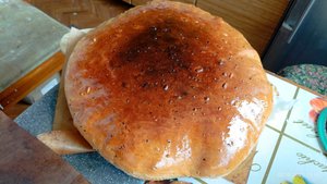 испёк каравайный каравай в обхват, с семечками и кунжутом,