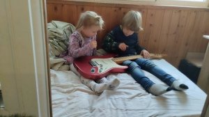 18 октября 2025 года дети играют с гитарой дома